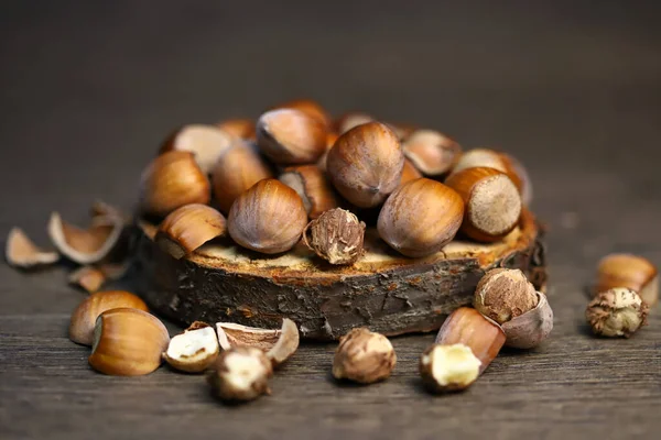 Hazelnuts, peeled and peeled on a wooden surface.