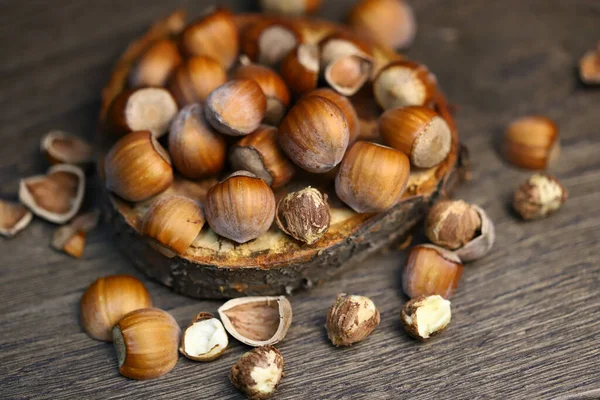 Hazelnuts, peeled and peeled on a wooden surface.