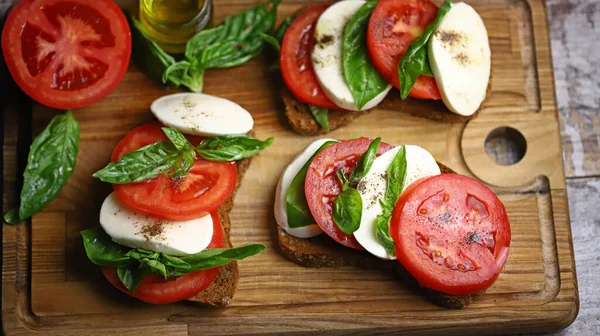 Tahtada Caprese sandviçleri var. Sağlıklı atıştırmalıklar. İtalyan yemeği..