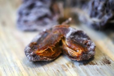 Dried persimmon on a wooden surface. Close.