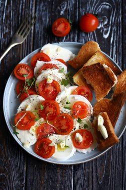 Sağlıklı salata, mozzarella ve tabakta vişneli domates. Diyet yemek. Düzgün beslenme. İtalyan yemeği..