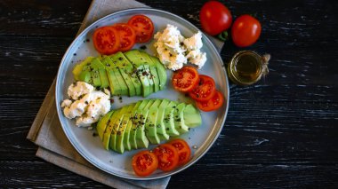 Avokado, vişneli domates ve krem peynirli tabak. Sağlıklı kahvaltı ya da atıştırmalık. Keto diyeti.