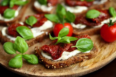 Sağlıklı tost, güneşte kurutulmuş domates ve fesleğen. İtalyan yemeği. Akdeniz atıştırmalığı.