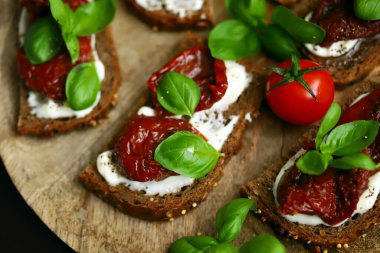 Sağlıklı tost, güneşte kurutulmuş domates ve fesleğen. İtalyan yemeği. Akdeniz atıştırmalığı.