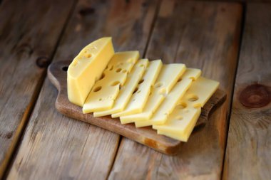 Tahta bir yüzeyde delik deşik olmuş peynir..