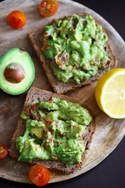 Seçici odaklanma. Makro. Tahta bir tahtanın üzerinde guacamole tostu. Sağlıklı yiyecekler. Keto diyeti.