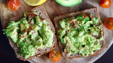 Seçici odaklanma. Makro. Tahta bir tahtanın üzerinde guacamole tostu. Sağlıklı yiyecekler. Keto diyeti.