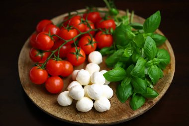 Caprese salatası için bir set ürün. Tahtada domates, fesleğen ve mozzarella..