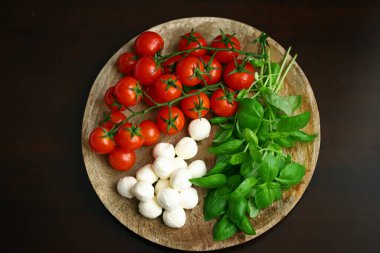 Caprese salatası için bir set ürün. Tahtada domates, fesleğen ve mozzarella..