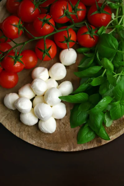Caprese salatası için bir set ürün. Tahtada domates, fesleğen ve mozzarella..