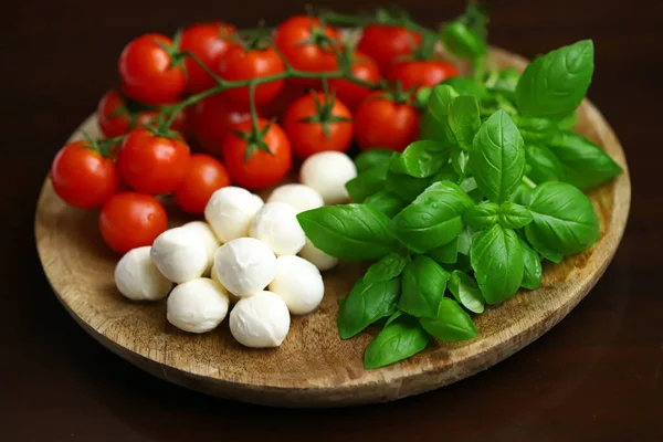 Caprese salatası için bir set ürün. Tahtada domates, fesleğen ve mozzarella..