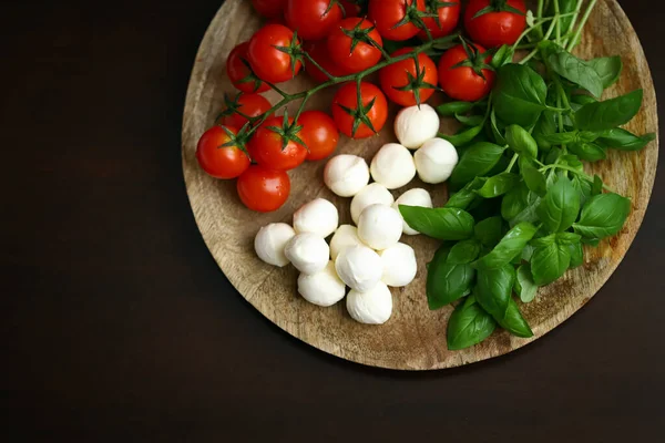 Caprese salatası için bir set ürün. Tahtada domates, fesleğen ve mozzarella..