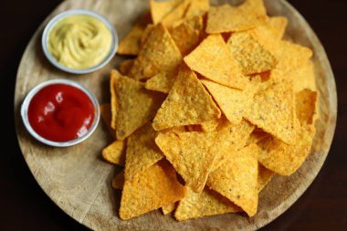 Tahta bir tahtanın üzerinde soslu mısır cipsi. Meksika yemeği.