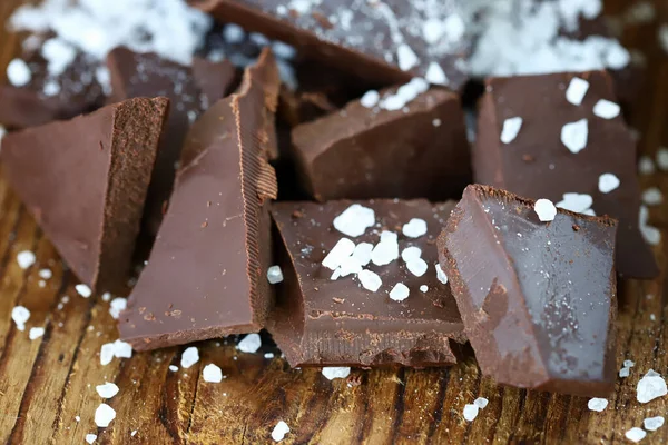 木制表面有盐的黑巧克力 — 图库照片
