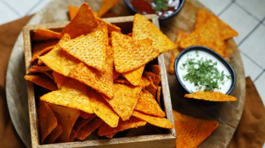 Seçici odaklanma. Tahta bir kasede soslu mısır cipsi..