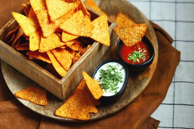 Seçici odaklanma. Tahta bir kasede soslu mısır cipsi..