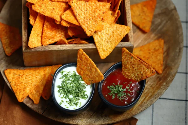 Seçici odaklanma. Tahta bir kasede soslu mısır cipsi..