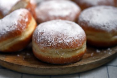 Ahşap tepside pudra şekerli Berlinli çörekler.