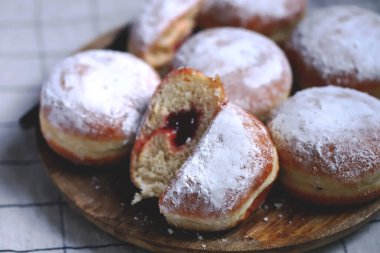 Ahşap tepside pudra şekerli Berlinli çörekler.