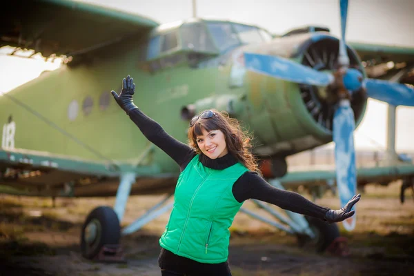 Girl staying near vintage aircraft