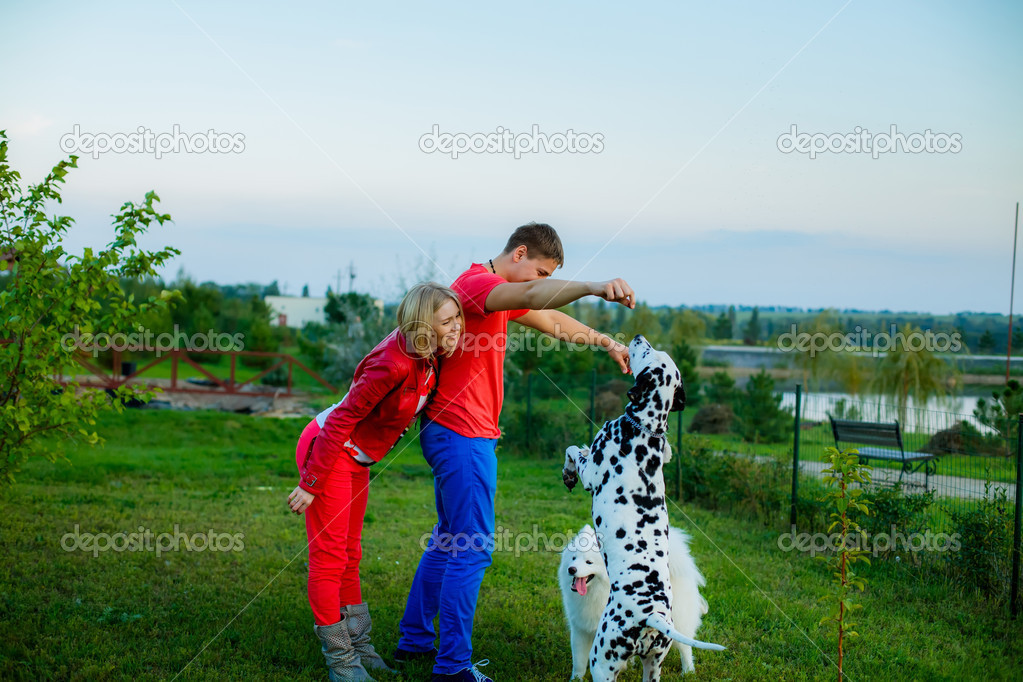 Husband and wife with dogs in a garden. — Stock Photo © HannaNes 31497569