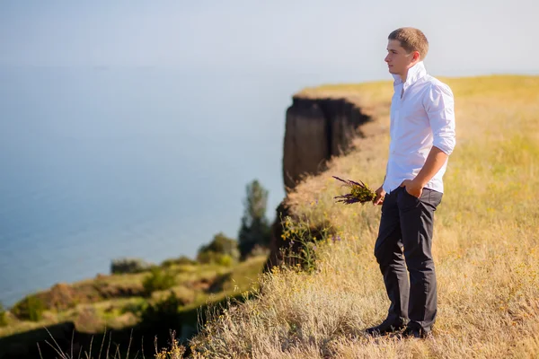 Guy with flowers on a cliff