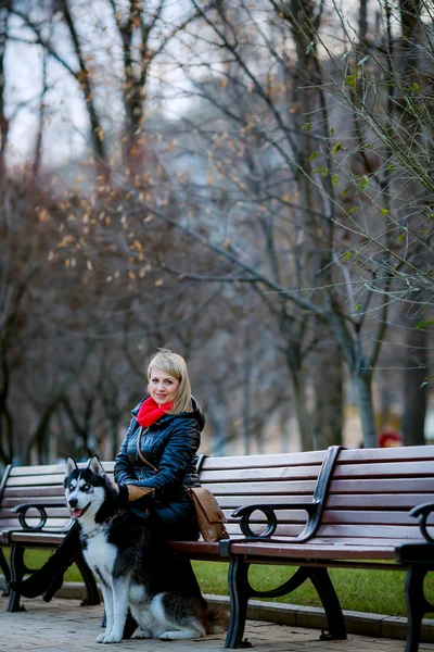 Woman and dog sitting on bench