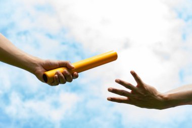 Close up hand set baton from hand to hand on sky background. Business concept for teamwork and team builder.