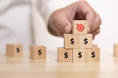 Elle yerleştirilen tahta bloğu, piramidin tepesinde hedef tahtası ile kapatın. Şirketin iş hedefi kavramı.