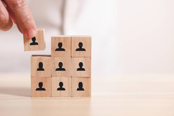 Hand place wooden blocks people icon. Concept for company and human resorce manangement.