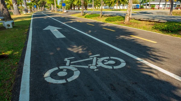 Mavi gökyüzü arka planlı bisikletçiler için yol ve büyük bir gölet.