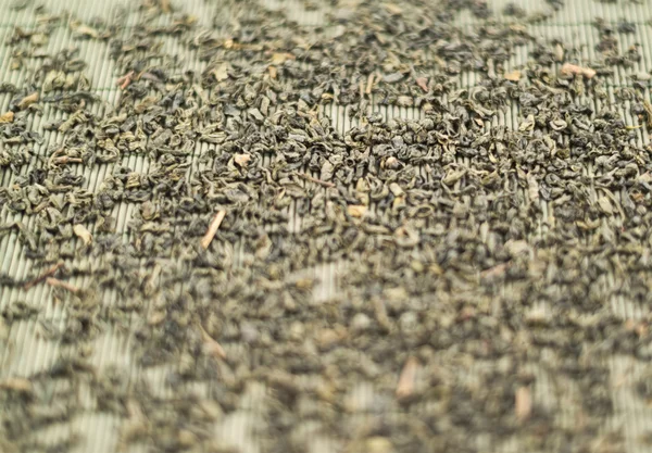 Black tea over bamboo mat — Stock Photo, Image