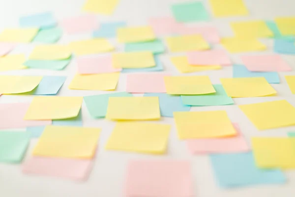 Veelkleurige papieren stickers op de muur — Stockfoto