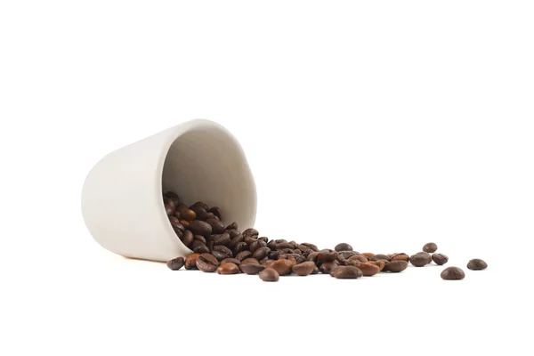 Verschüttete Kaffeebohnen aus der Tasse isoliert — Stockfoto