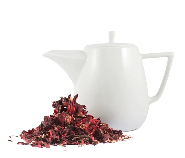 Ceramic teapot next to pile of tea isolated — Stock Photo, Image