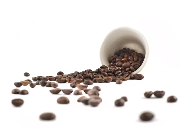 分離されたカップからのコーヒー豆をこぼした — ストック写真