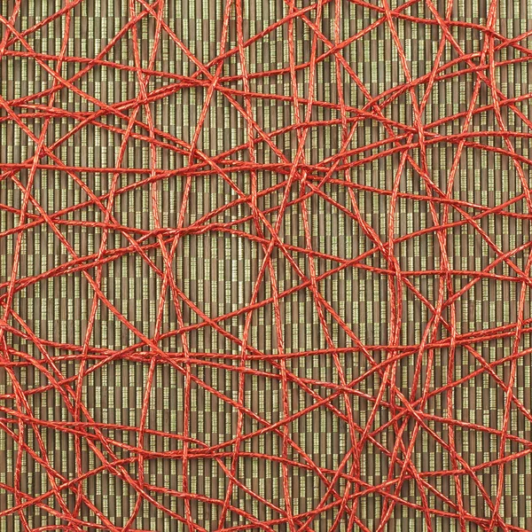 Bamboo mat covered with red thread — Stock Photo, Image