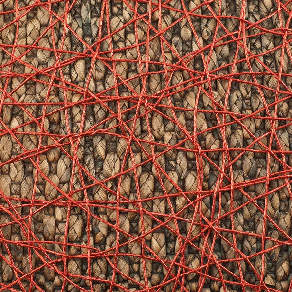 Wicker mat covered with red thread — Stock Photo, Image