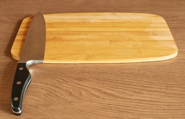 Cutting board and cook's knife — Stock Photo, Image