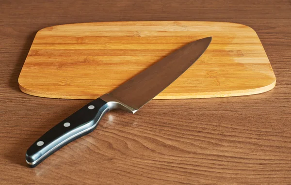 Cutting board and cook's knife — Stock Photo, Image