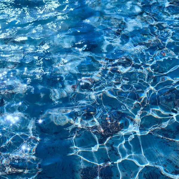 Отражения и волны голубой воды — стоковое фото
