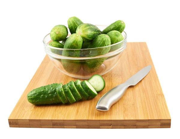 Slicing cucumber over a cutting board — Stock Photo, Image