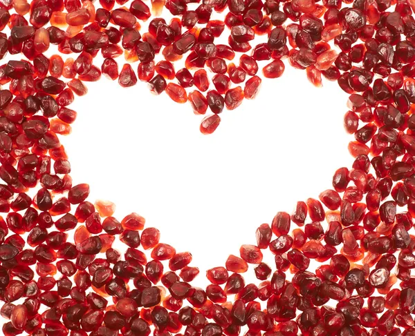 Heart shaped frame of pomegranate seeds — Stock Photo, Image