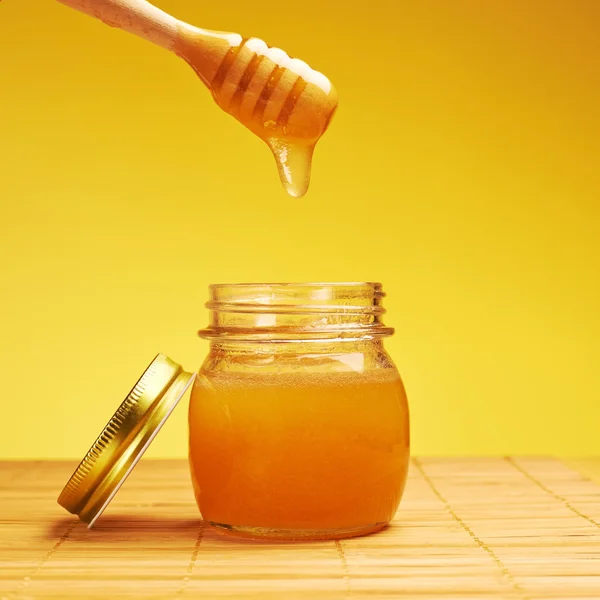 Honey jar with wooden dipper composition — Stock Photo, Image