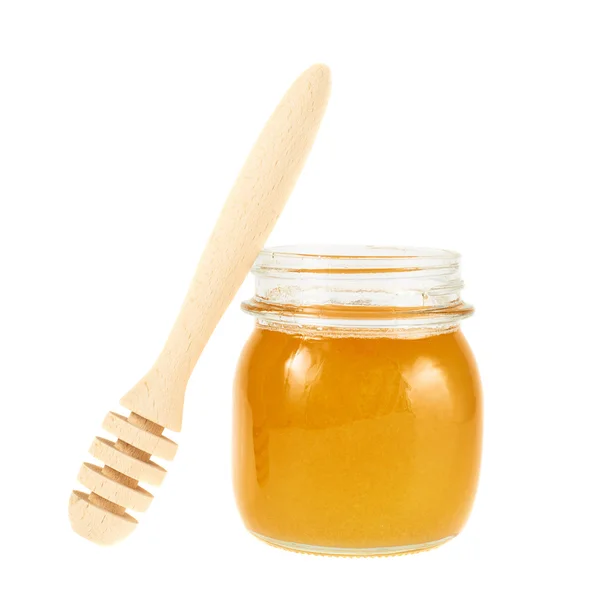 Honey dipper next to a jar — Stock Photo, Image