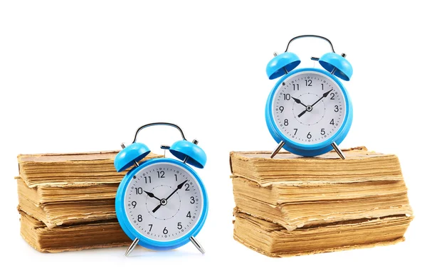 Blue alarm clocks next to a books stack — Stock Photo, Image