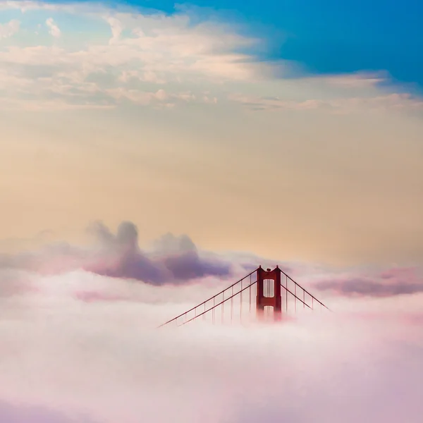 World Famous Golden Gate Bridge Surrounded by Fog after Sunrise in San Francisco, Californiaa Стоковое Изображение