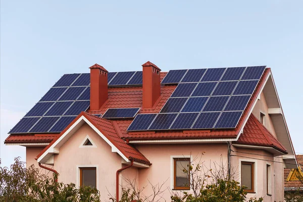 Özel evin çatısındaki güneş panelleri bacanın etrafına monte edilmiş. Alternatif enerji kavramı.