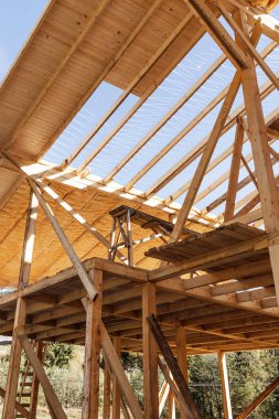 Construction of  Wooden Roof. Construction of frame wooden house. Wooden building. Fibreglass insulation. 