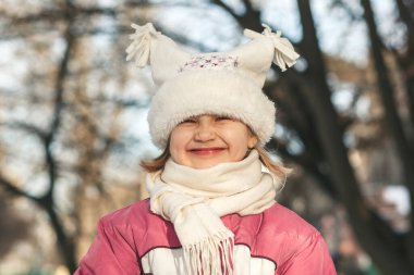 Kış bebek portresi, yüz. Parkta kışın kameraya bakan mutlu, güler yüzlü kız çocuğu.. 